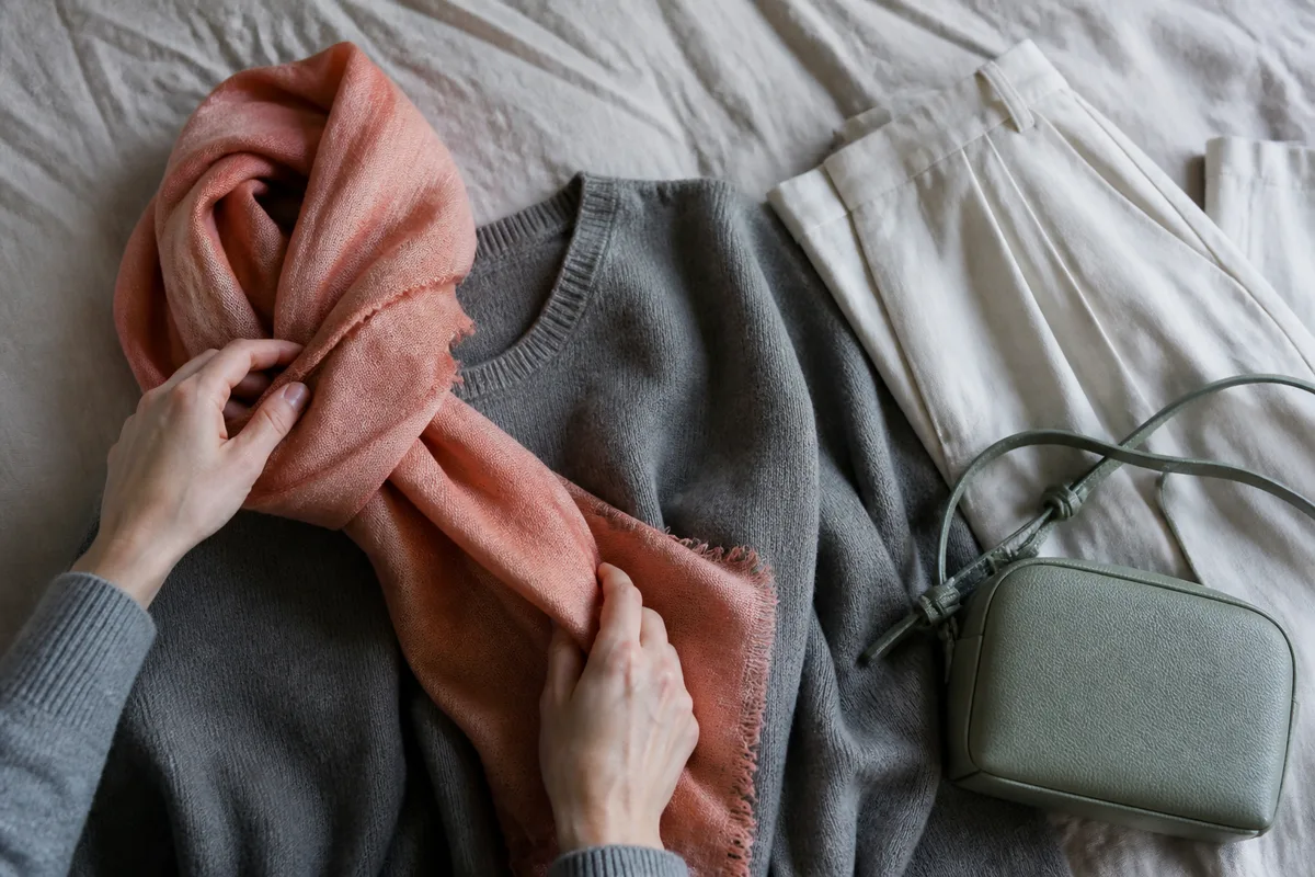 Tenue neutre posée à plat rehaussée d’un foulard et d’un sac colorés